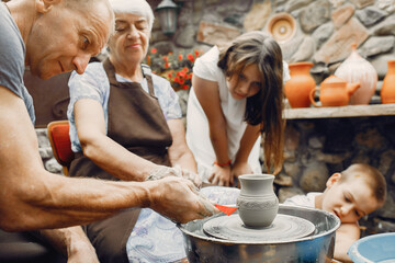 Family make a small jug. Hands of a potter at work.