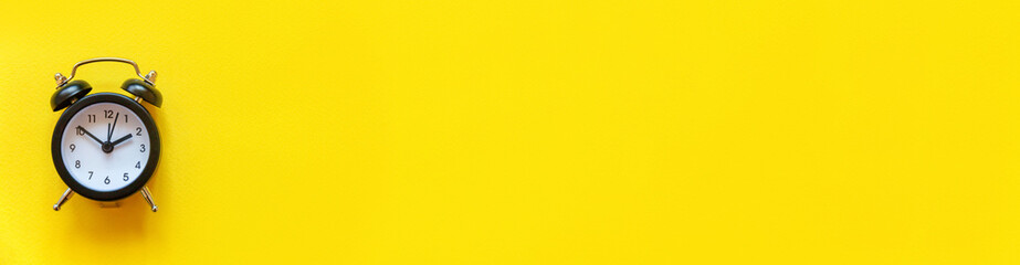 Simply minimal design ringing twin bell vintage classic alarm clock Isolated on yellow background....