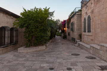 Fototapeta na wymiar Residential buildings on the HaMigdal Street in the Jerusalem Mishkenot Sheananim - Hutzot Hayotzer quarter in the light of the rays of the setting sun in Jerusalem, Israel