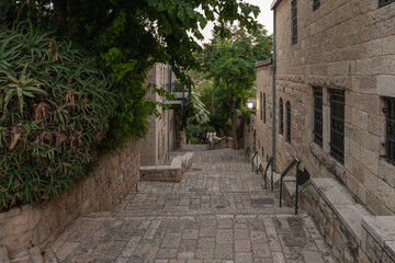 Obraz premium Residential buildings on the HaMigdal Street in the Jerusalem Mishkenot Sheananim - Hutzot Hayotzer quarter in the light of the rays of the setting sun in Jerusalem, Israel