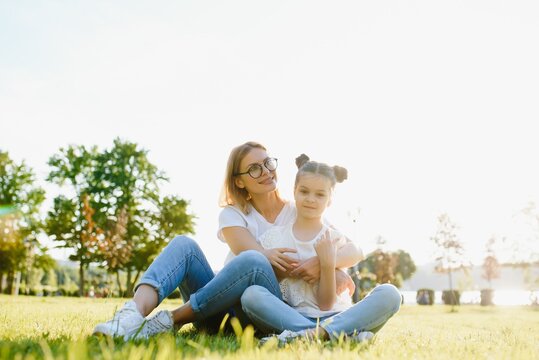 Lifestyle portrait mom and daughter in happines at the outside in the meadow