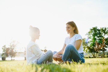 Fototapeta premium Lifestyle portrait mom and daughter in happines at the outside in the meadow