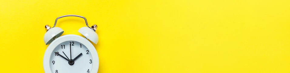 Simply minimal design ringing twin bell classic alarm clock Isolated on yellow background. Rest...