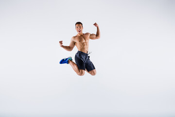 Full length body size view of his he nice attractive sportive cheerful cheery guy jumping having fun rejoicing cup winning isolated over light white pastel color background
