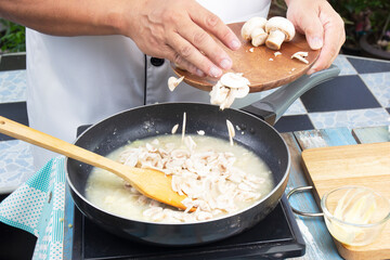 Chef pouring slice of mushroom for cook cream soup