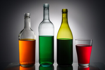 bottles and glasses with various color liquids