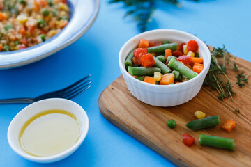 frozen vegetables on the table in a plate. blue background
