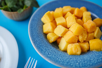 cubes of frozen pineapple in a blue plate close-up