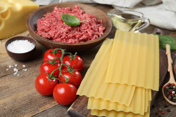 Fresh ingredients for lasagna on wooden table