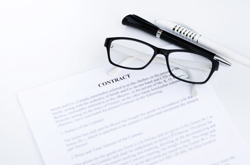 The contract lies on a white background. Business concept