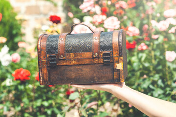 Woman holding a locked antique chest in her hands