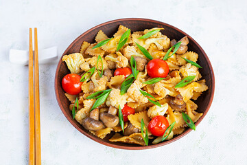 Stir fry farfalle pasta with vegetables, cauliflower and mushrooms