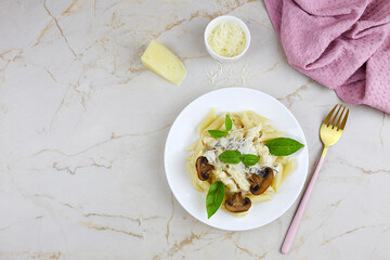 Penne pasta with mushrooms in cream sauce, basil and parmesan.