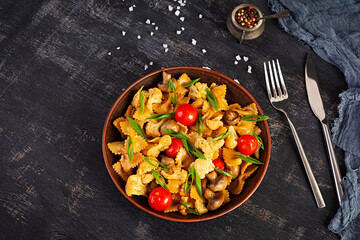 Stir fry farfalle pasta with vegetables, cauliflower and mushrooms. Top view