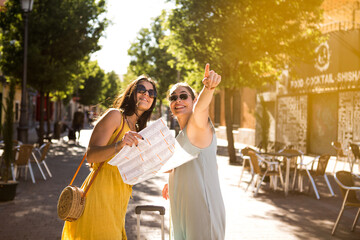 two tourists looking for their hotel on a map