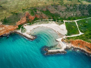 Fotobehang Bolata strand, Balgarevo, Bulgarije Bolata Beach, Kaap Kaliakra, aan de noordkust van Bulgarije. De hoge steile oevers van een roodachtige tint zijn in harmonie met het groen van gras en de eindeloze blauwe zee. Uitzicht vanaf drone.