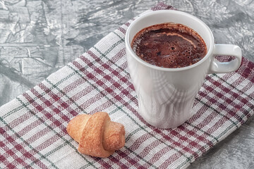 Coffee with cream and freshly baked puffs on a gray background