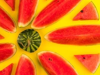 Fresh ripe watermelon slices on yellow background.