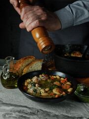 Cooking meatballs cutlets and vegetables in big pan and serving  by portion in plate on home kitchen background with ingredients. Copy space, closeup. Healthy food recipe book concept