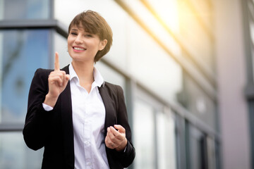 an expressive and happy businesswoman outside