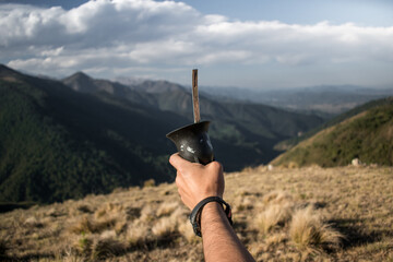 mano sosteniendo un mate en cima de cerro © Enzo Baspineiro