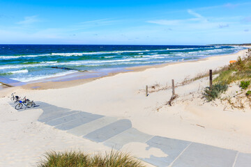 Entrance to beautiful white sand beach and blue sea near Kolobrzeg (board translation: coastal sand dunes) , Baltic Sea coast, Poland