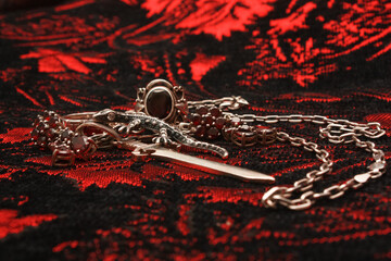 Silver pendant in the shape of a sword on an anchor chain, silver set of earrings and rings with...