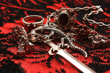 Silver pendant in the shape of a sword on an anchor chain, silver set of earrings and rings with...