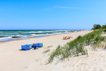 KOLOBRZEG BEACH - MAY 31, 2020: Tourists on beautiful white sand beach and blue sea near Kolobrzeg,...