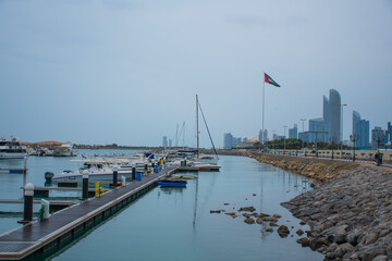 Motorboats & yachts parked at the Abu Dhabi Marina on a rainy day with the Abu Dhabi skyline at the back