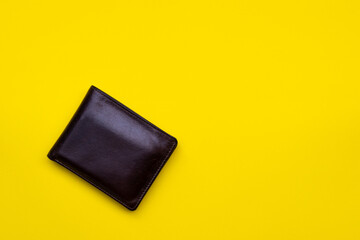 Brown leather wallet on yellow background