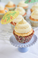 tropical cupcake with vanilla icing and paper umbrella