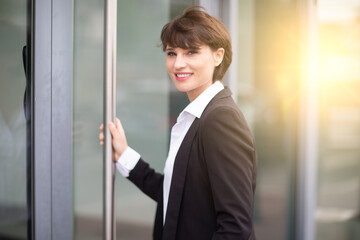 portrait of a woman working in an office posing in front of her business