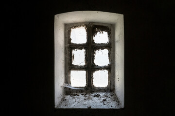 Mysterious old window with a dusty glass covered with spider web