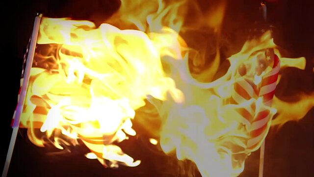 Burning flag of USA (United State of America) catching fire and rapidly burning. Used with economic crisis, metaphor economy collapse concepts. Slow motion