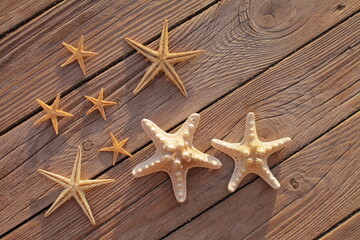 Fototapeta na wymiar Starfish on a wooden pier poured over a wooden deck. Summer vacation concept. Holidays by the sea