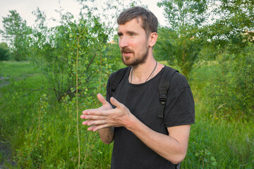 Young bearded man outdoors in nature. Camping in the woods.