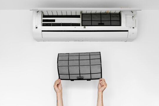 The guy cleans the filter of the home air conditioner from dust. Very dirty air conditioner filter. Climate equipment care.