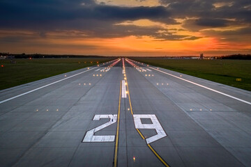 Aerial view on empty airport runaway with markings for landings, designation 29 and all navigation lights on at the colorful sunset, clear for airplane landing or taking off in Wroclaw  airport