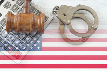 Financial fraud concept, judge wooden gavel and handcuffs on table and flag of United States