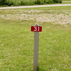 A close view of the mile marker on the grass trail in park.
