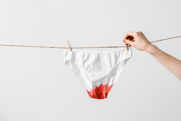 Woman hangs underwear on clothesline, concept content for feminist blog, poster about women's health and menstruation - obrazy, fototapety, plakaty