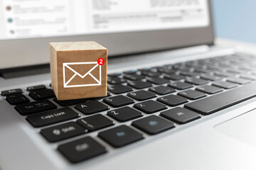 Fototapeta New email symbol on wooden block on laptop keyboard obraz