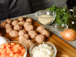 Meatball cutlet cooking by homemade recipe with farm meat, organic vegetables, herbs and spices by man cook hands on kitchen background