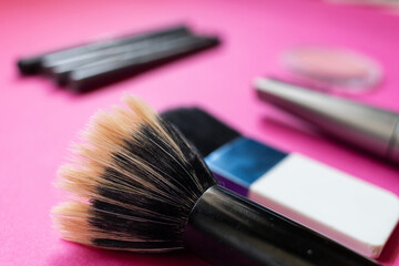 Make up products, brushes, lipstick, eyeliner on a pink background. Beauty concept