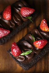Rectangular chocolate tart with strawberry set in cafe table.