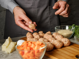 Meatball cutlet cooking by homemade recipe with farm meat, organic vegetables, herbs and spices by man cook hands on kitchen background