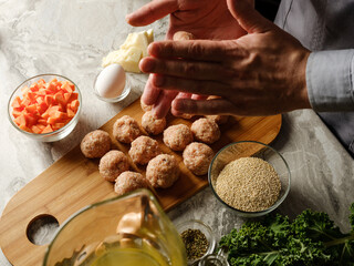 Cutlet meatball with farm minced meat cooking  by chef hands with vegetables, herbs, spices and other ingredients by family recipe  on home kitchen background with ingredients