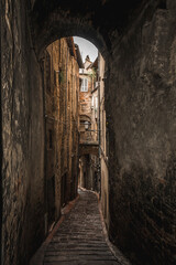 Fototapeta na wymiar one of the many alleys of the historic center of Perugia with typically medieval tones