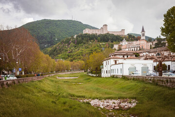 Fototapeta premium the bed of a dry river gently accompanies the observer on the hill that houses the Fortress of Spoleto